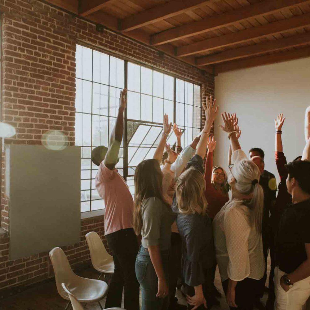 Group of diverse people raising their hands in the air