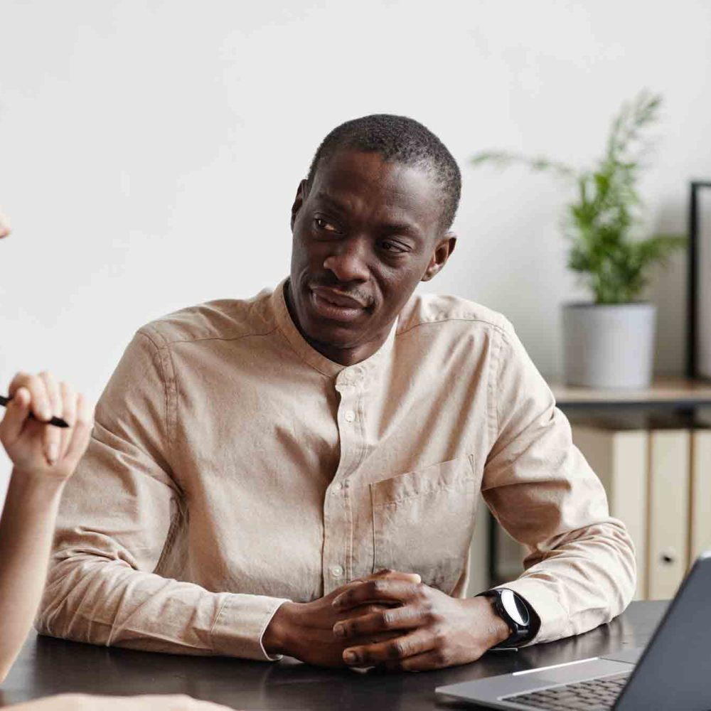 Minimal portrait of two modern business people discussing project at desk in office, copy space